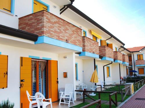 洛萨皮内塔Apartment Solmare-7 by Interhome的庭院里设有橙色门和椅子的房子