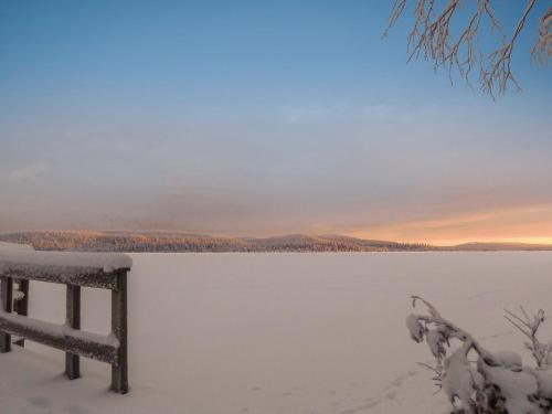 RauhalaHoliday Home Äkäsjärven lomamökit 3 by Interhome的冰冻湖的地面雪景