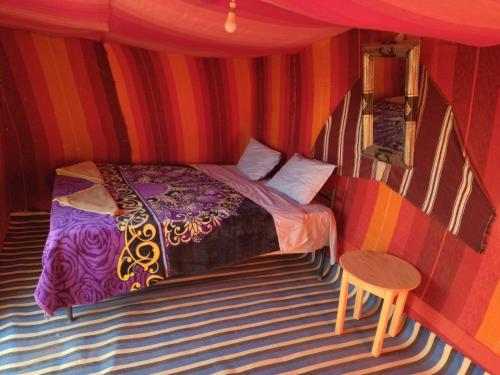 El GoueraChegaga Nomad Camp的一间位于条纹间的卧室,配有一张床