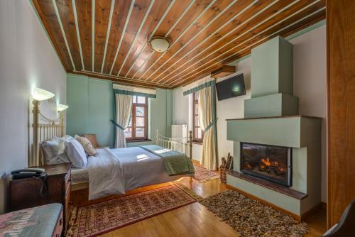 Asprangeloi阿尔孔斯科克拉那酒店的一间卧室配有一张床和一个壁炉
