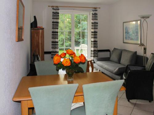 高尔维茨Apartment Gollwitzer Park - Insel Poel-9 by Interhome的客厅配有一张桌子和橘子花瓶