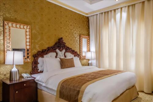 沙迦Crystal Plaza Al Majaz Hotel的一间卧室配有一张大床和镜子