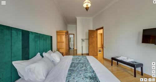 第比利斯Octava Boutique Hotel的一间卧室配有一张大床和绿色床头板