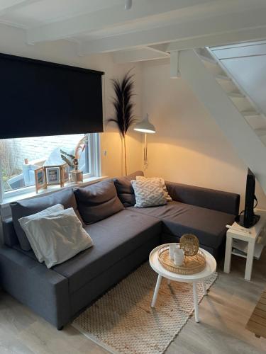 滨海卡特韦克Vakantiehuis Katwijk Andreasplein的客厅配有沙发和桌子