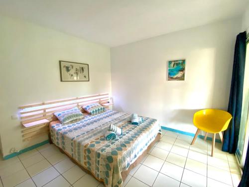 莱特鲁瓦西莱Studio Carayou & Spa的一间卧室配有一张床和一张黄色椅子