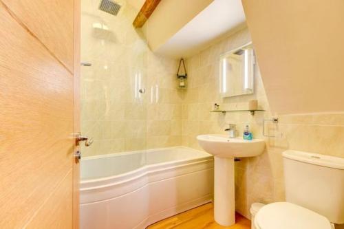 惠特比Sleepy Hollow的浴室配有盥洗盆、卫生间和浴缸。