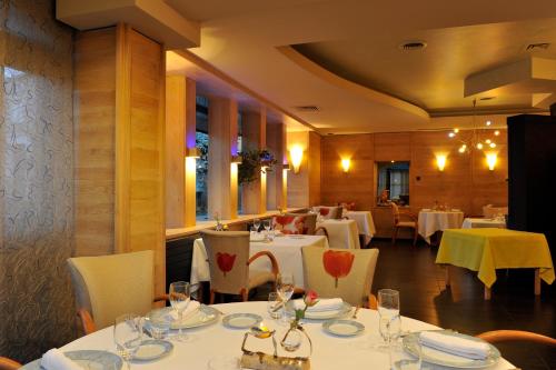 阿雷瑞斯上阿里尔酒店的用餐室配有白色的桌子和白色的椅子