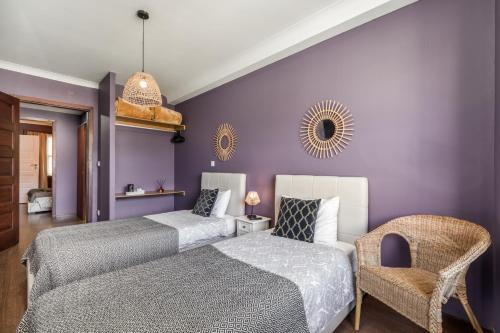 波尔图Oporto Santa Catarina Residence的紫色卧室配有两张床和一把椅子