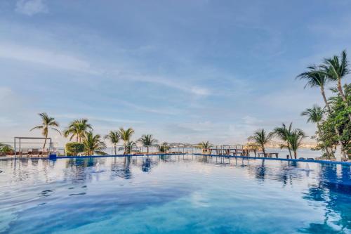 阿卡普尔科Fiesta Americana Acapulco Villas的一座棕榈树和海洋的大型游泳池