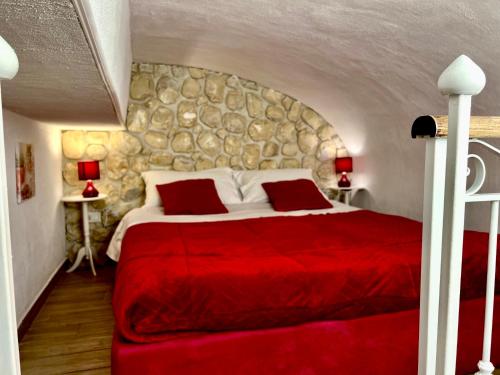 巴勒莫Le Chalet Palermo Centro的一间卧室配有一张红色的床和石墙
