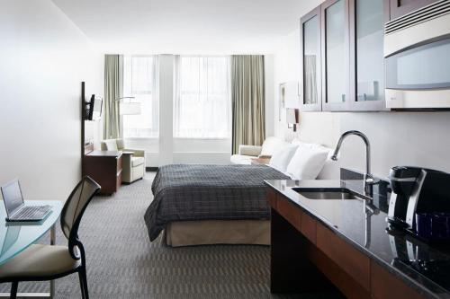 芝加哥河畔酒店的大型酒店客房设有床和厨房