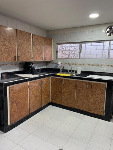 巴兰基亚MonDieu Hostel的厨房配有木制橱柜和黑色台面