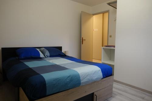 费康Tout un 2eme étage à 300 mètres de la mer, chez l'habitant !的一间卧室配有一张带蓝色和白色棉被的床