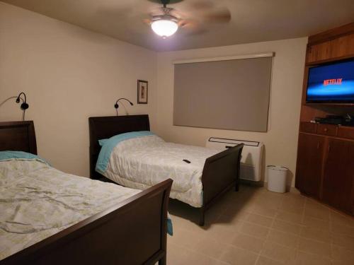 卡沃罗霍Private Beachfront House的一间卧室配有两张床和一台平面电视