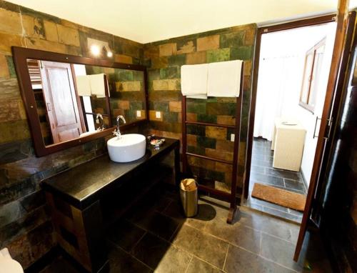 Nīleshwar卡南海滩度假村的一间带水槽、镜子和淋浴的浴室