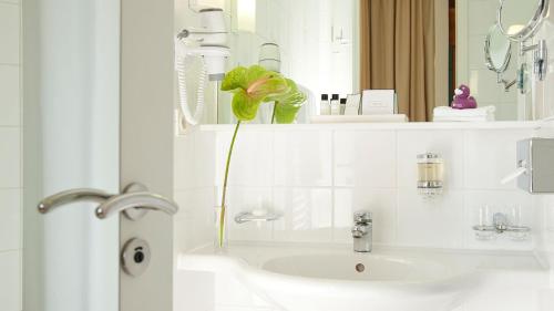 柏林柏林亚美隆亚里安斯普林伯根酒店的白色的浴室设有水槽和镜子