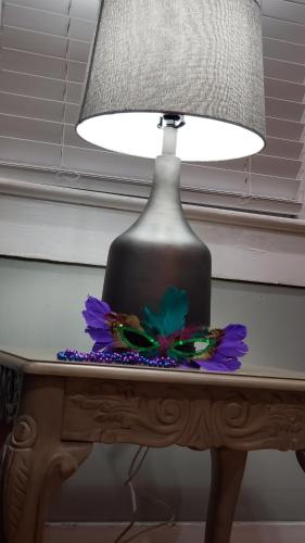莫比尔The Lafayette House的桌子上的一盏灯,上面有一朵花