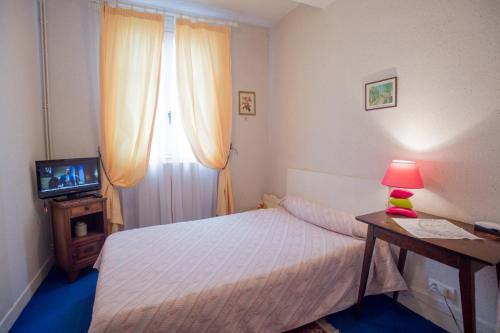 巴涅尔德比戈尔Hôtel Saint Vincent的一间小卧室,配有一张床和电视
