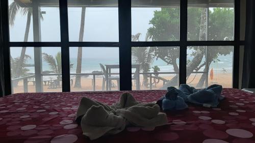 爱妮岛Duli Beach Resort的一张带毛巾的床,享有海滩美景