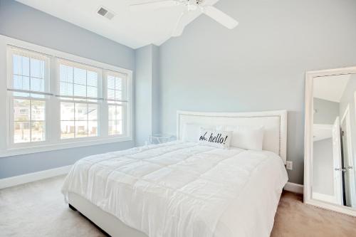 默特尔比奇Carnation 302的白色的卧室设有白色的床和窗户。