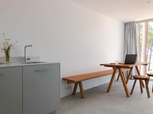 里贝拉Apartamentos Camping Coroso的厨房配有长凳和桌上笔记本电脑