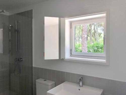 里贝拉Apartamentos Camping Coroso的一间带水槽和镜子的浴室以及窗户。