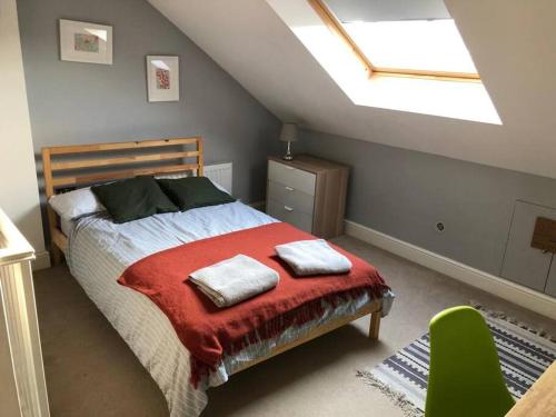 伦敦Twickes Townhouse的一间卧室配有一张带红色毯子和天窗的床。