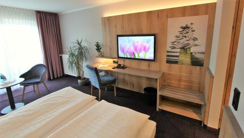 吕贝克托马赫勒酒店的酒店客房配有书桌和电视。