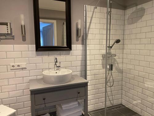 BreklumFriesen-Lodge Ferienwohnungen的白色的浴室设有水槽和淋浴。