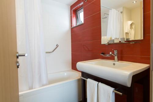 蒙得维的亚丽晶路蒙得维迪亚酒店的浴室配有水槽、淋浴和浴缸。
