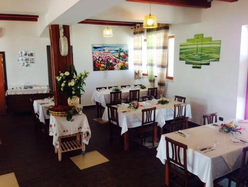 莫尔费塔Agriturismo La Ferrovia的餐厅设有白色的桌椅和鲜花