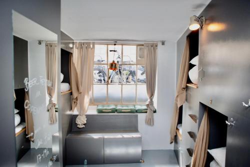 哥本哈根Woodah Hostel的小房间设有窗户和靠窗的座位