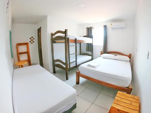 马拉戈日Maragogi Hostel的客房设有两张双层床和一张桌子。
