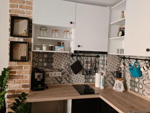 大特尔诺沃Апартамент (Студио) Тони的厨房配有白色橱柜和砖墙