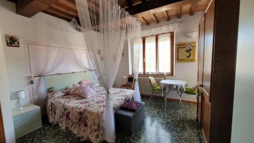 圣奎里科-多尔恰Camera La Margherita的一间卧室配有一张带天蓬的床