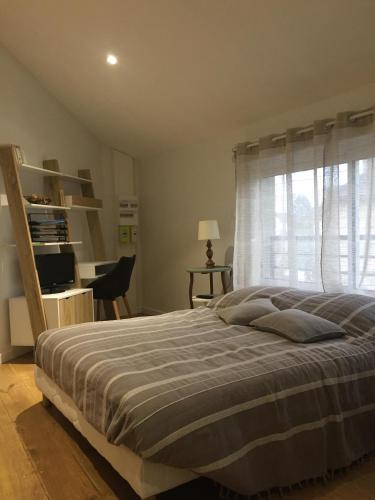 香槟沙隆La Bulle的一间卧室配有一张床、一张书桌和一个窗户。