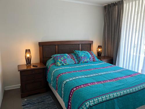 维纳德马Excelente Departamento en Reñaca的一间卧室配有一张床、两盏灯和一个窗户。