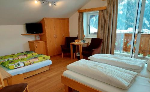 大格洛克纳山麓卡尔斯贝格尔霍夫木屋的酒店客房设有两张床和窗户。