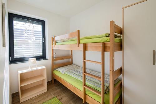 巴诺夫茨Apartmaji BANONIA " Poletni vetrc "的一间小卧室,配有双层床和窗户