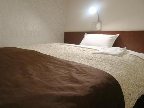 滨松Hamamatsu Station Hotel - Vacation STAY 65843的卧室配有一张带白色枕头的大床