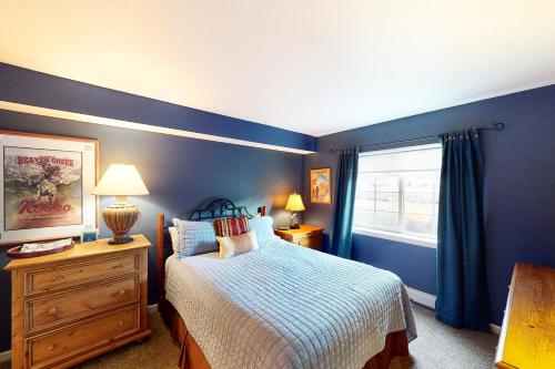 爱德华兹Riverside Treehouse的蓝色的卧室设有床和窗户