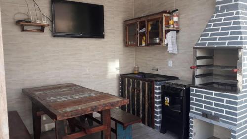 佩尼亚Pousada Miguel Penha Sc的厨房配有炉灶、桌子和电视。