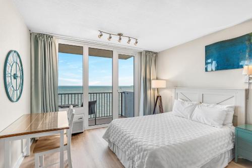 德斯坦Sandestin Resorts, Bayside, 3rd Floor, Bay Front Studio的一间卧室配有一张床、一张书桌和一个窗户。
