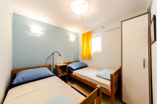 苏佩塔尔Apartman Supetar的带两张床和镜子的客房