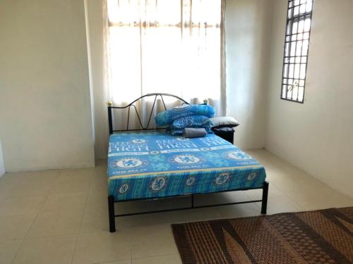 阿罗士打Homestay Chik Da的一间卧室配有一张带蓝色毯子的床和窗户。