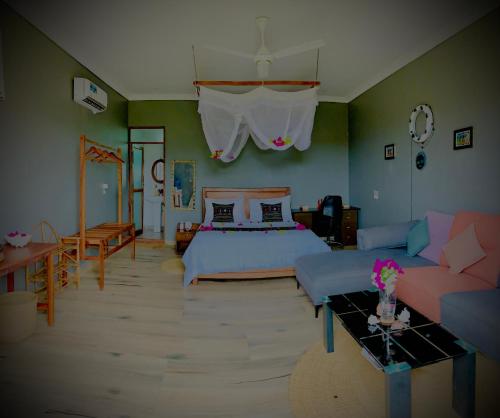 乌罗阿Uroa Getaway的一间卧室配有一张床和一张沙发
