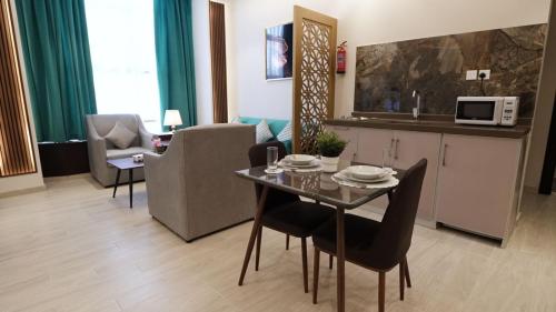 吉达المنار للوحدات الفندقية的一间带桌椅的客厅和一间厨房