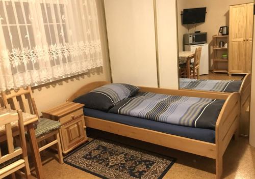 马达伯乐斯拉夫Modrý Pension的卧室配有一张床和一张桌子及椅子