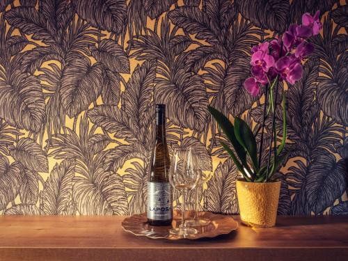 巴拉通尤洛克Panorama Home的鲜花桌子上的一瓶葡萄酒和玻璃杯