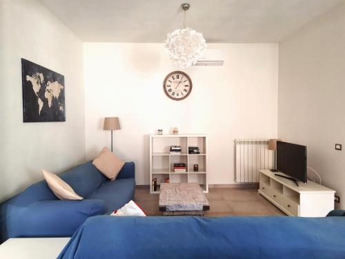 维亚雷焦Casa di Nicola的客厅配有蓝色的沙发和时钟